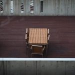 Des tables en bois et chaises sur une terrasse de béton