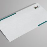 Enveloppe blanche à bandes vertes, logo discret, sur fond gris neutre