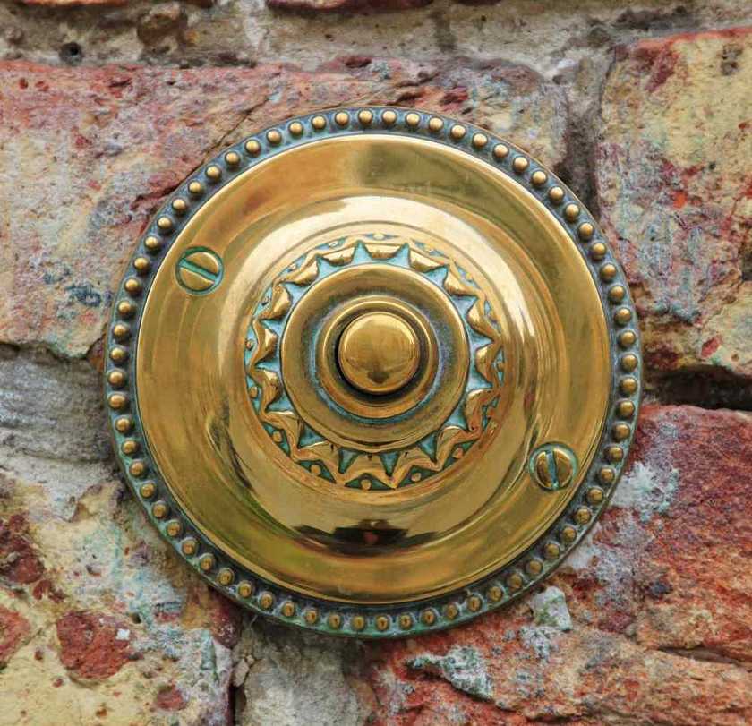 Bouton doré sur un mur en pierre